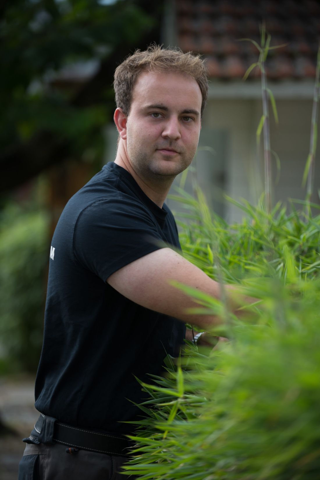 Jan Staudinger neben einer Hecke im Garten